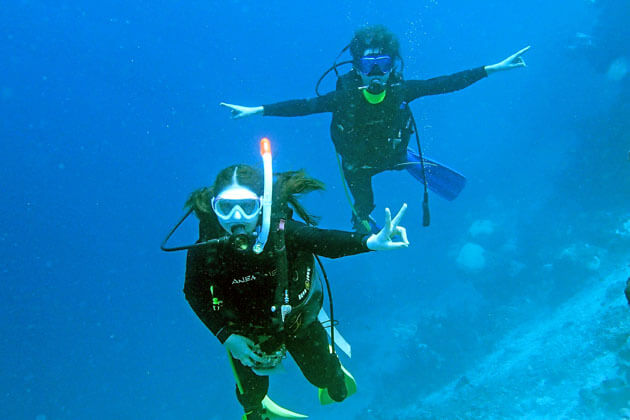 水中で記念撮影するダイビングカップル
